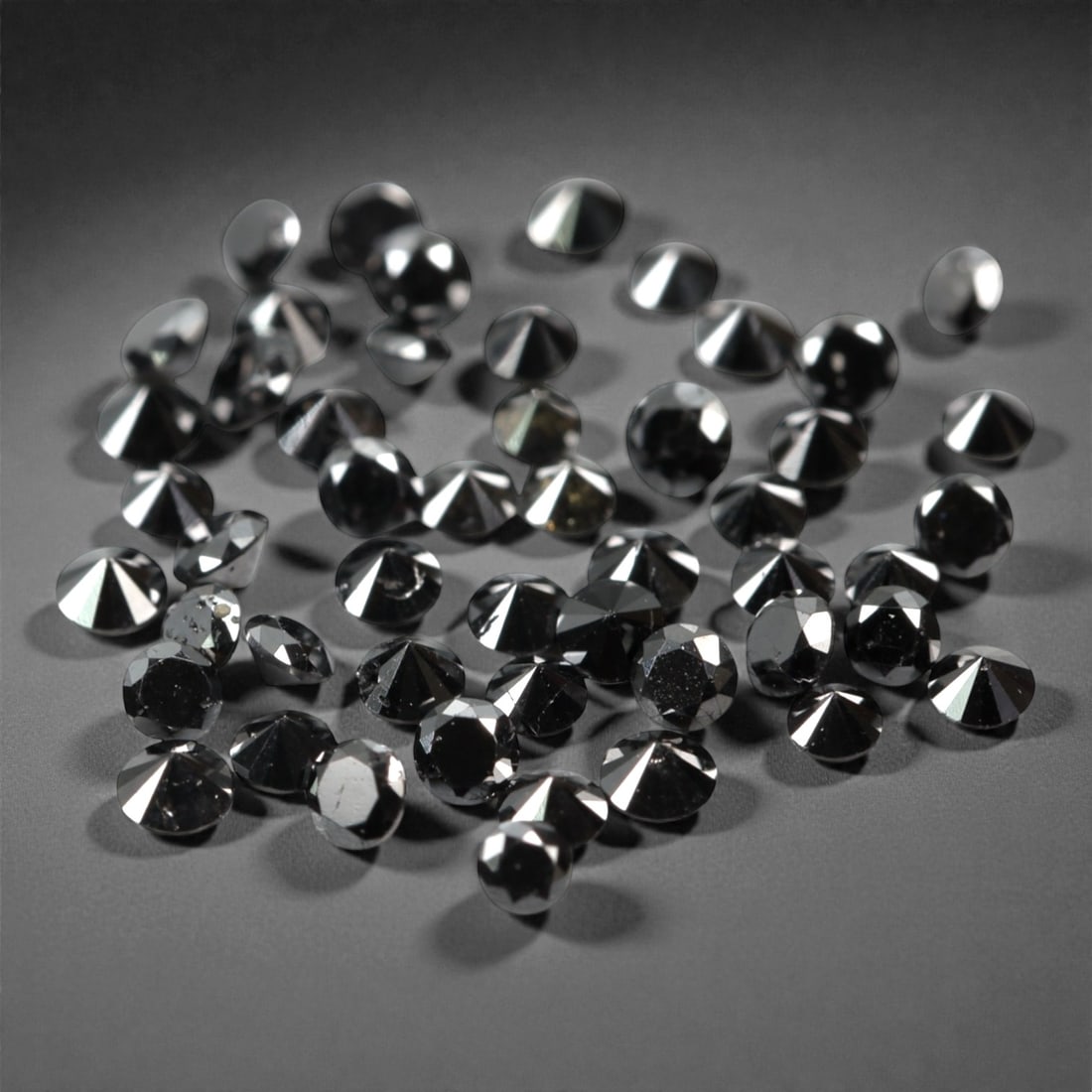 50 Pieces Black Diamond Parcel - Round Brilliant Cut, 1.7mm, 178A: This versatile parcel of 50 loose black diamond gems captivates with a deep, opaque black hue that evokes the intensity of polished obsidian and the mystery of a midnight sky. Each stone is cut in a w