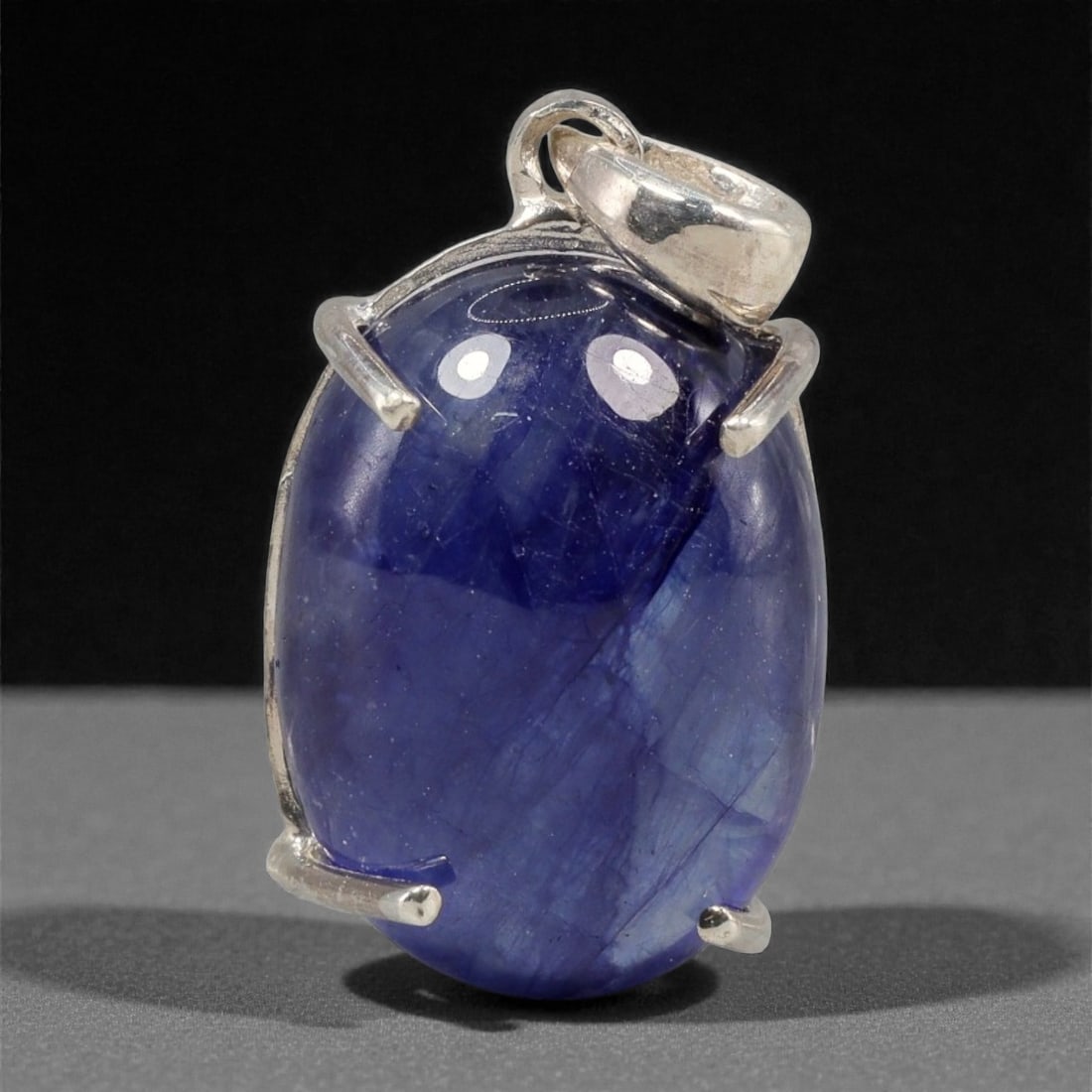14.02 Carats Deep Blue Sapphire Cabochon Pendant - Sterling Silver Setting, 155A: This striking pendant features a substantial deep blue sapphire cabochon, set in a polished sterling silver frame stamped 925. The cabochon's smooth, domed surface radiates with a rich, velvety blue h