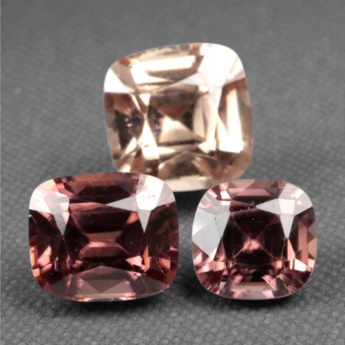 3.13 Carats Pinkish Brown Zircon Parcel - Natural Sri Lankan Stones, 334A: This striking parcel of three loose zircon gems captivates with a warm, pinkish-brown hue that evokes the richness of aged rosewood and the glow of a setting sun. Each stone is cut in a well-proportio