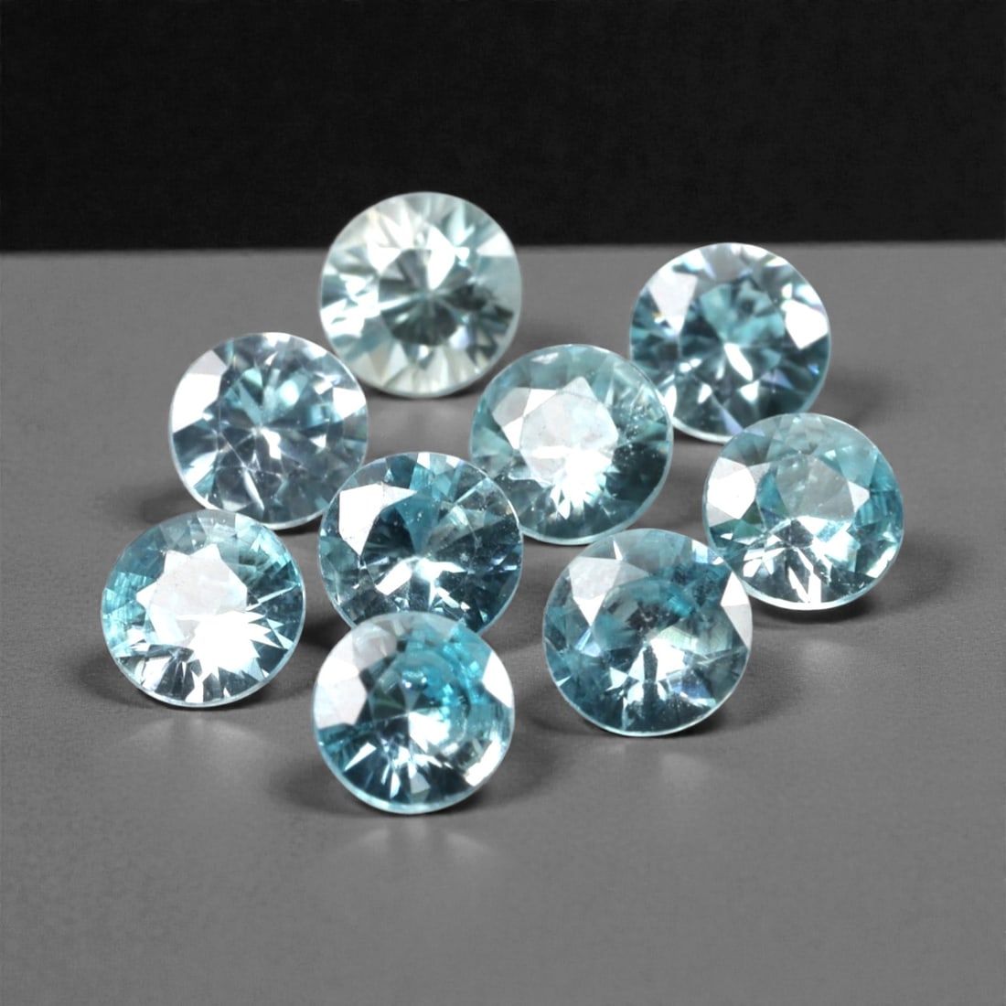 3.17 Carats Sky Blue Zircon Selection - Natural Cambodian Stones, 383A: This curated selection of nine round-cut zircon gems presents a serene, sky-blue hue, reminiscent of clear tropical waters and open summer skies. Each stone is precision-faceted to maximize light disp