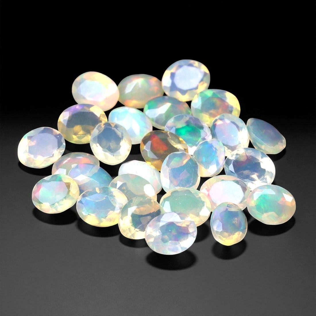 5.71 Carats Oval Cabochon Opal Parcel - Natural Welo Ethiopian Stones, 84XC: This mesmerizing parcel features 5x4 mm oval-cut opals, each glowing with exceptional play-of-color across a luminous, translucent body. Flashes of electric green, oceanic blue, and golden orange shif
