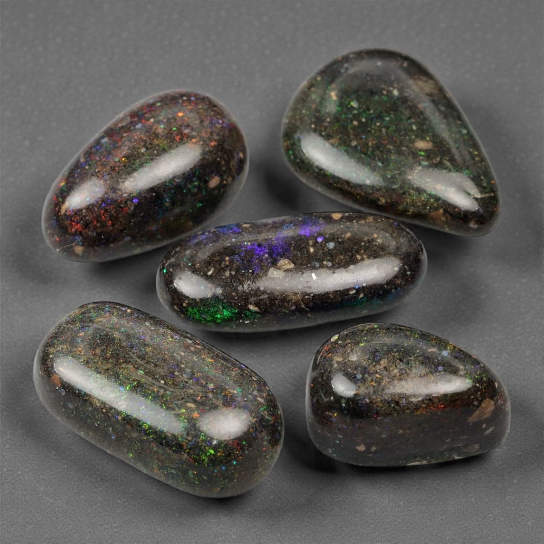 23.76 Carats Dark Matrix Opal Parcel - Natural Australian Stones, 12-17mm, 1XK: This expressive parcel of matrix opals reveals a rich interplay of earthy tones and fire-filled flashes. Bursts of red, green, violet, and blue flicker across dark, ironstone-like backgrounds, produci