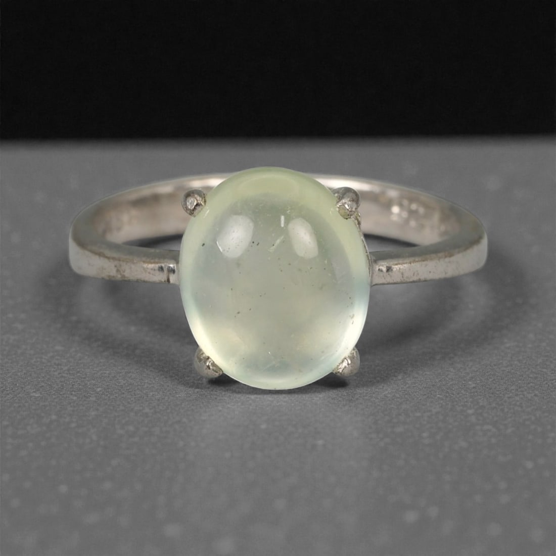 Prehnite Cabochon Ring - Natural Gemstone in Silver-Tone Setting - 6.25 US, 46XK: This graceful ring features a translucent prehnite cabochon in a soft celadon green hue, cradled in a four-prong silver-tone setting. The gem's smooth, rounded dome reveals subtle internal textures an