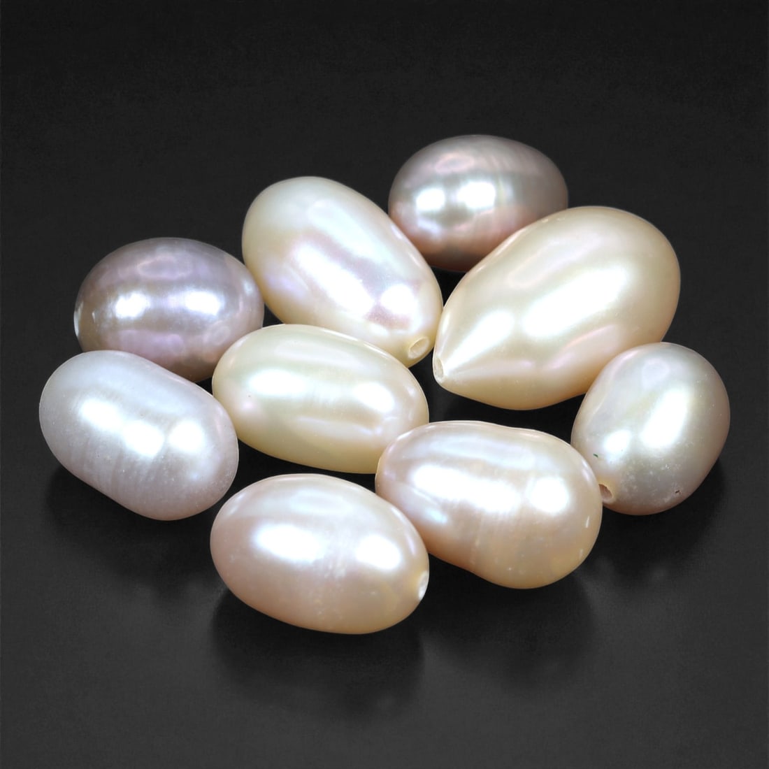 6.4 Grams Champagne to Lavender Pearl Lot - Natural 8-13 mm Drop Shapes, 33XC: This elegant lot of freshwater pearls displays a soft, pastel spectrum of blush pink, silvery white, and gentle lavender tones. Ranging from 8 to 13 mm in length, each pearl exhibits a classic drop to