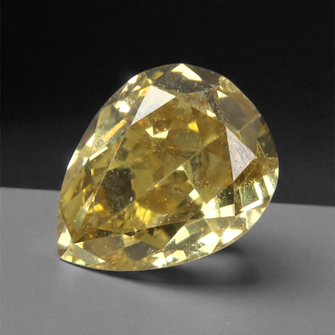 0.34 Carats Fancy Intense Yellow Diamond - Natural South African Origin, 44DA: This 0.34 carat fancy intense yellow diamond dazzles with a rich, saturated canary hue that radiates warmth and vibrancy from every precisely cut facet. The pear-shaped form enhances the stone's natur