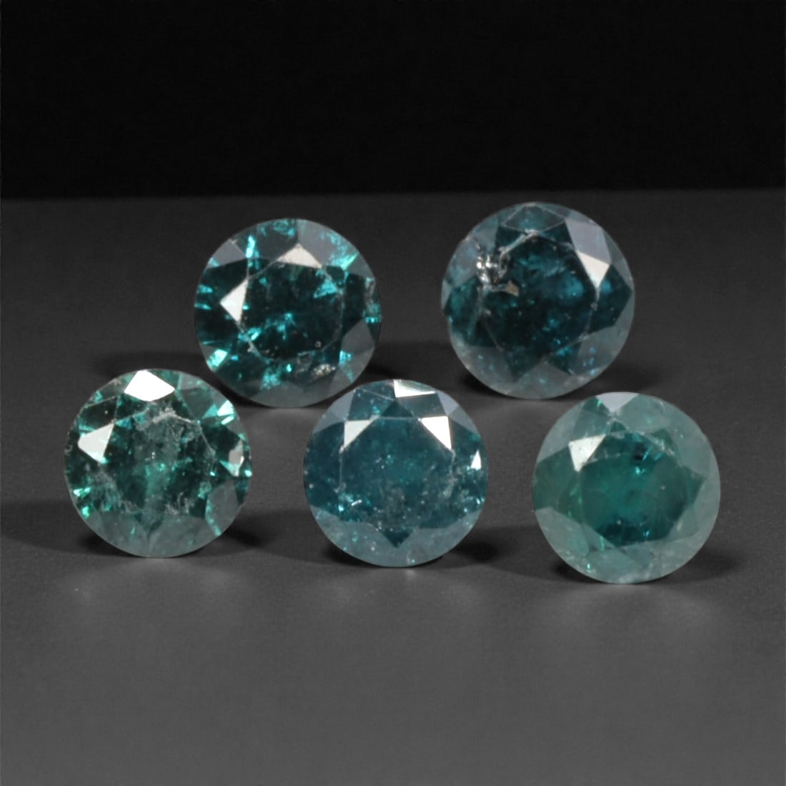 5 Pieces Irradiated Blue Diamond Parcel - Round Brilliant Cut, 2.4mm, 251A: This striking parcel of five loose irradiated blue diamond gems captivates with a vivid, cool blue hue that evokes the intensity of a deep ocean and the clarity of a winter sky. Each stone is cut in a