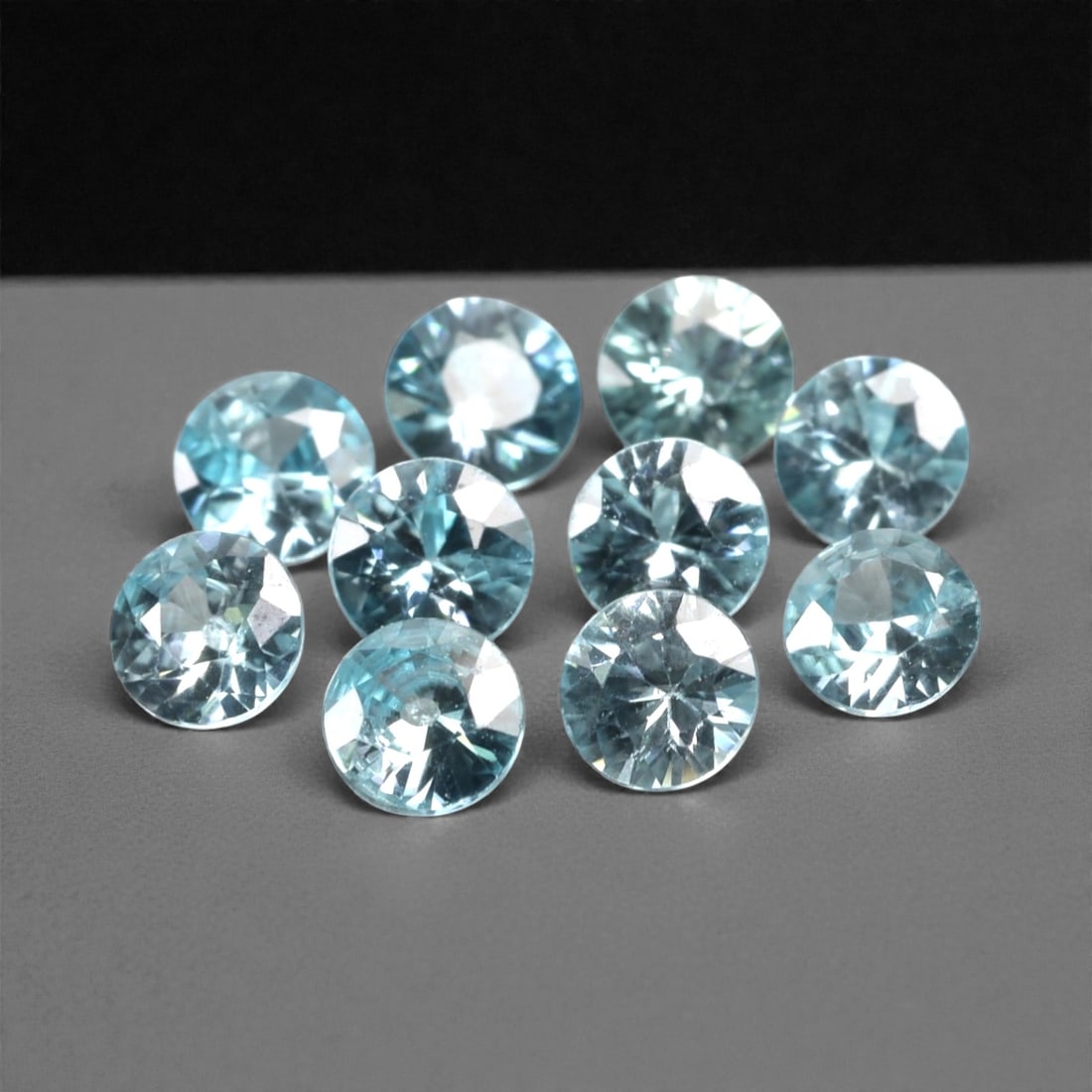 3.32 Carats Sky Blue Zircon Selection - Natural Cambodian Stones, 384A: This curated selection of ten round-cut zircon gems presents a serene, sky-blue hue, reminiscent of clear tropical waters and open summer skies. Each stone is precision-faceted to maximize light dispe