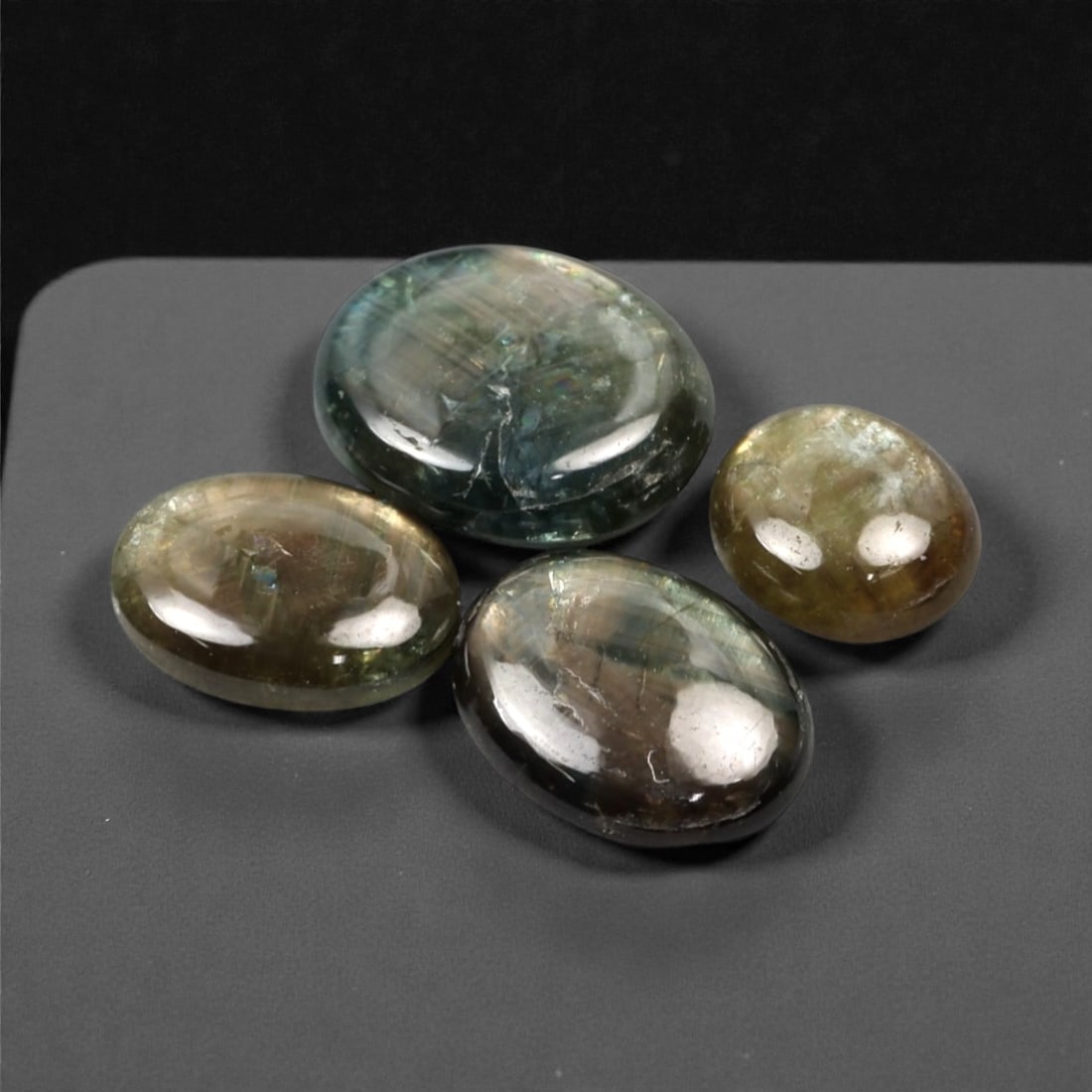 4.45 Carats Multicolor Star Sapphire Selection - Natural Ceylon Origin, 304A: This curated selection of four cabochon-cut star sapphires showcases the ethereal, natural beauty of these gemstones, with an earthy palette of deep green, muted brown, and iridescent tones. Each smoo