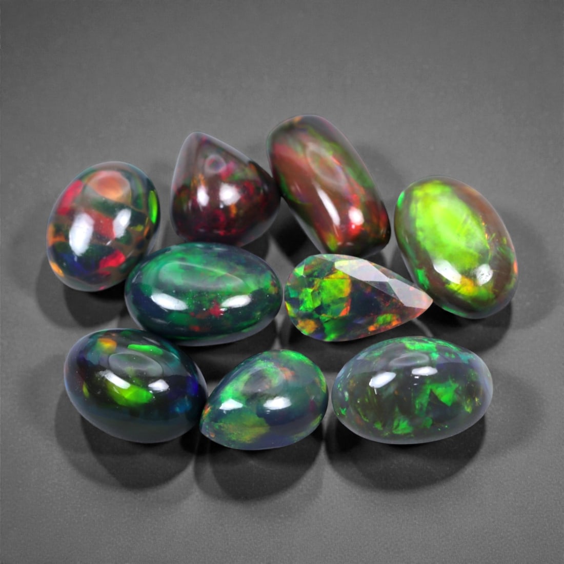 16.69 Carats Neon Black Opal Parcel - Natural Ethiopian Stones, 9-13mm, 58XH: This striking parcel of natural black opals erupts with vivid, high-contrast color against dark, inky body tones. Electric greens, fiery reds, and bursts of violet and orange flash across each surface