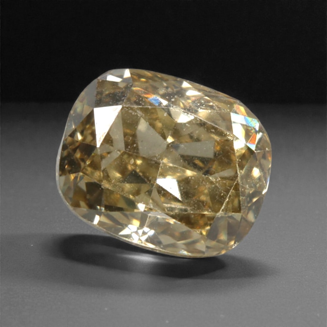 0.26 Carats Fancy Deep Brownish Yellow Diamond - Natural South African Origin, 40DA: This 0.26 carat fancy deep brownish yellow diamond captivates with a rich, earthy hue that evokes the warmth of aged amber and the depth of fine cognac. The cushion modified brilliant cut enhances the