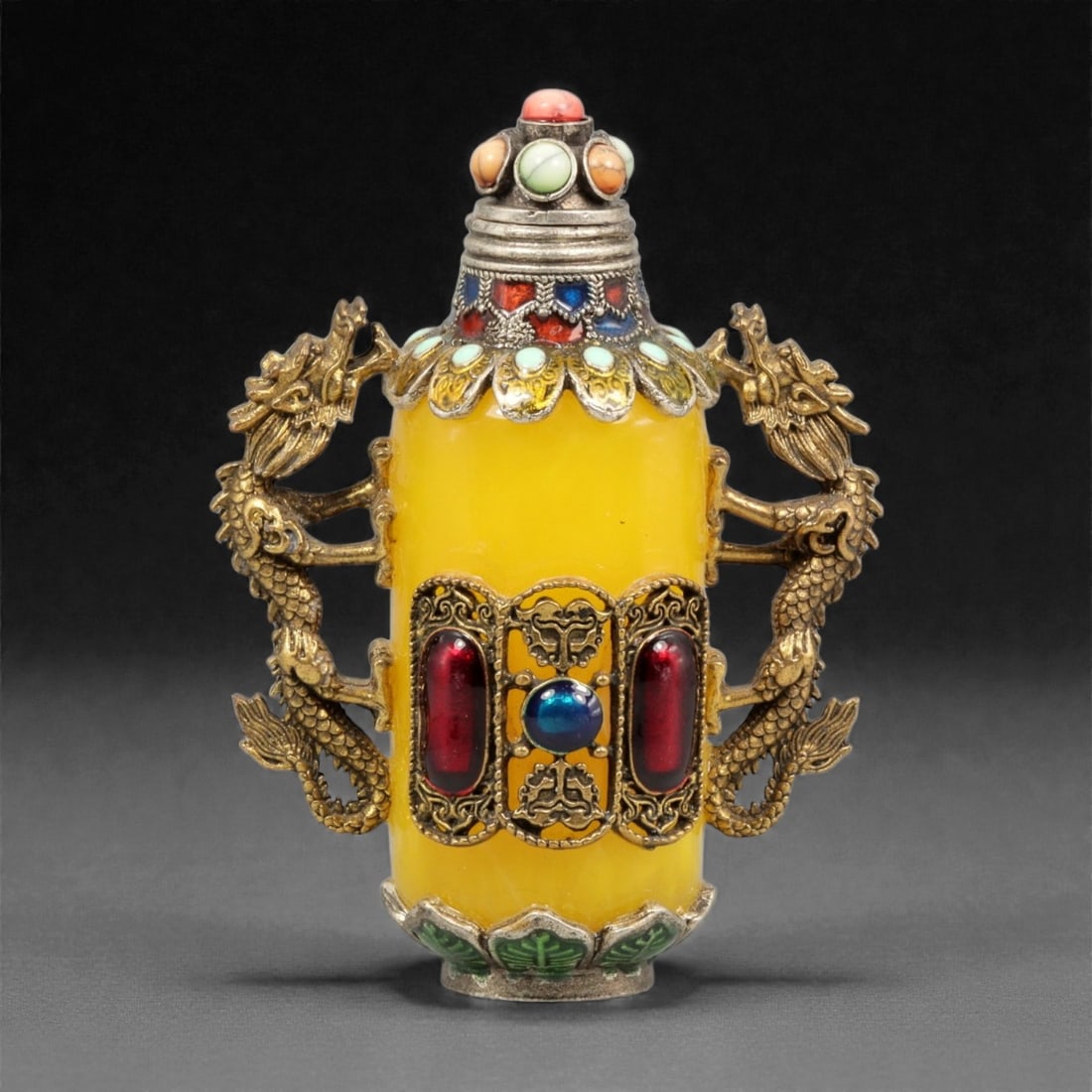 A Chinese Amber-Resin and Brass-Mounted Snuff Bottle, 20th Century, 1YC: Formed from translucent yellow amber-colored resin, the bottle is cylindrical in profile with a slightly tapering body rising from a small circular foot. The exterior is encased in an elaborate openwo