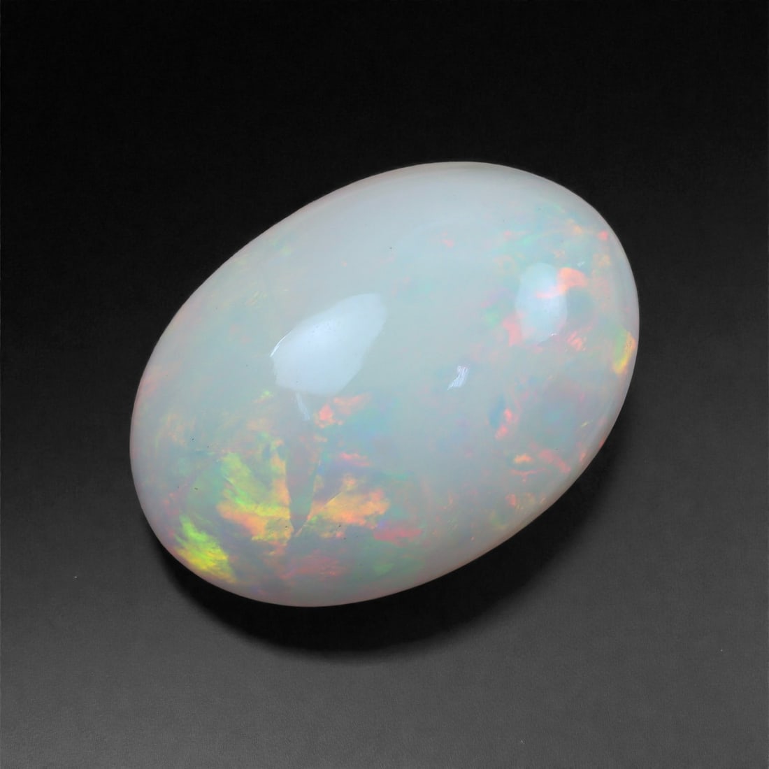 6.66 Carats Aurora Flame Welo Opal - Natural Ethiopian Gemstone 15.8x11.2x7.5mm, 52XH: This opal radiates with the fiery glow of a living aurora, featuring sweeping flashes of neon green, golden orange, and deep rose woven beneath a silky translucent surface. The gem's wide body and hig