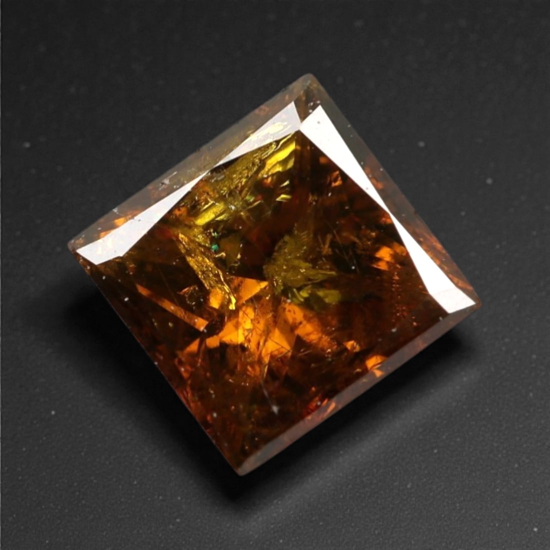 0.36 Carats Orangy Red Fancy Diamond - Princess Cut, 187A: This rare fancy orangy red diamond captivates with a vivid, warm hue that evokes the intensity of a glowing ember and the richness of a sunset. Cut in a well-proportioned princess shape, the stone's f