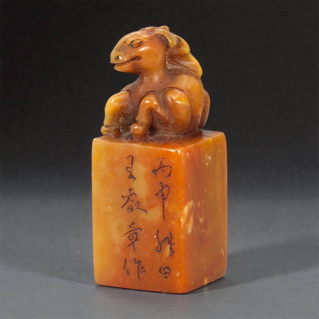 A Chinese Shoushan Stone Horse-Form Seal, 20th Century, 15FA: Carved from warm amber-toned Shoushan stone with natural translucency and subtle tonal variation, the seal is surmounted by a recumbent horse modeled in the round. The animal is rendered with a rounde