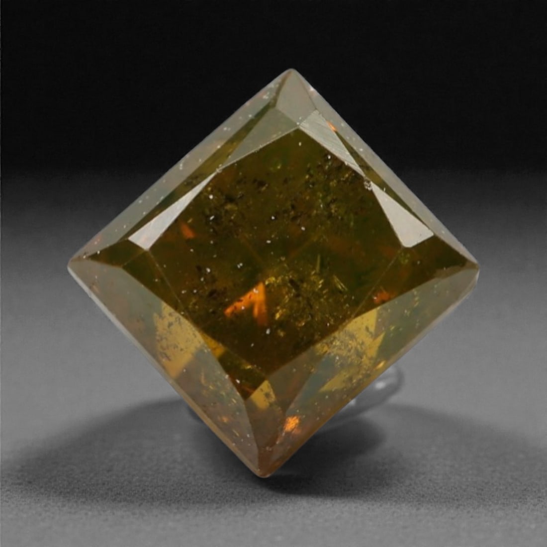 0.50 Carats Orangy Red Fancy Diamond - Princess Cut, 181A: This rare fancy orangy red diamond captivates with a vivid, warm hue that evokes the intensity of a glowing ember and the richness of a sunset. Cut in a well-proportioned princess shape, the stone's f