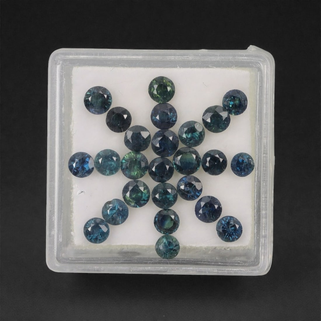 5.11 Carats Multitone Parti Sapphire Parcel - Natural Australian Stones, 24XL: This vibrant parcel of parti sapphires showcases a rich spectrum of deep teal, forest green, and moody blue tones, each round, faceted stone exhibiting dynamic color zoning that shifts and glows under