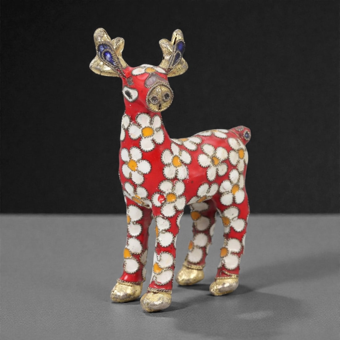 A Chinese Cloisonne Enamel Deer Effigy, 20th Century, 99FG: Constructed from a copper alloy body and decorated with cloisonne enamel, the figure is formed as a standing deer with the head raised and slender legs evenly spaced to support the body. Fine metal wi