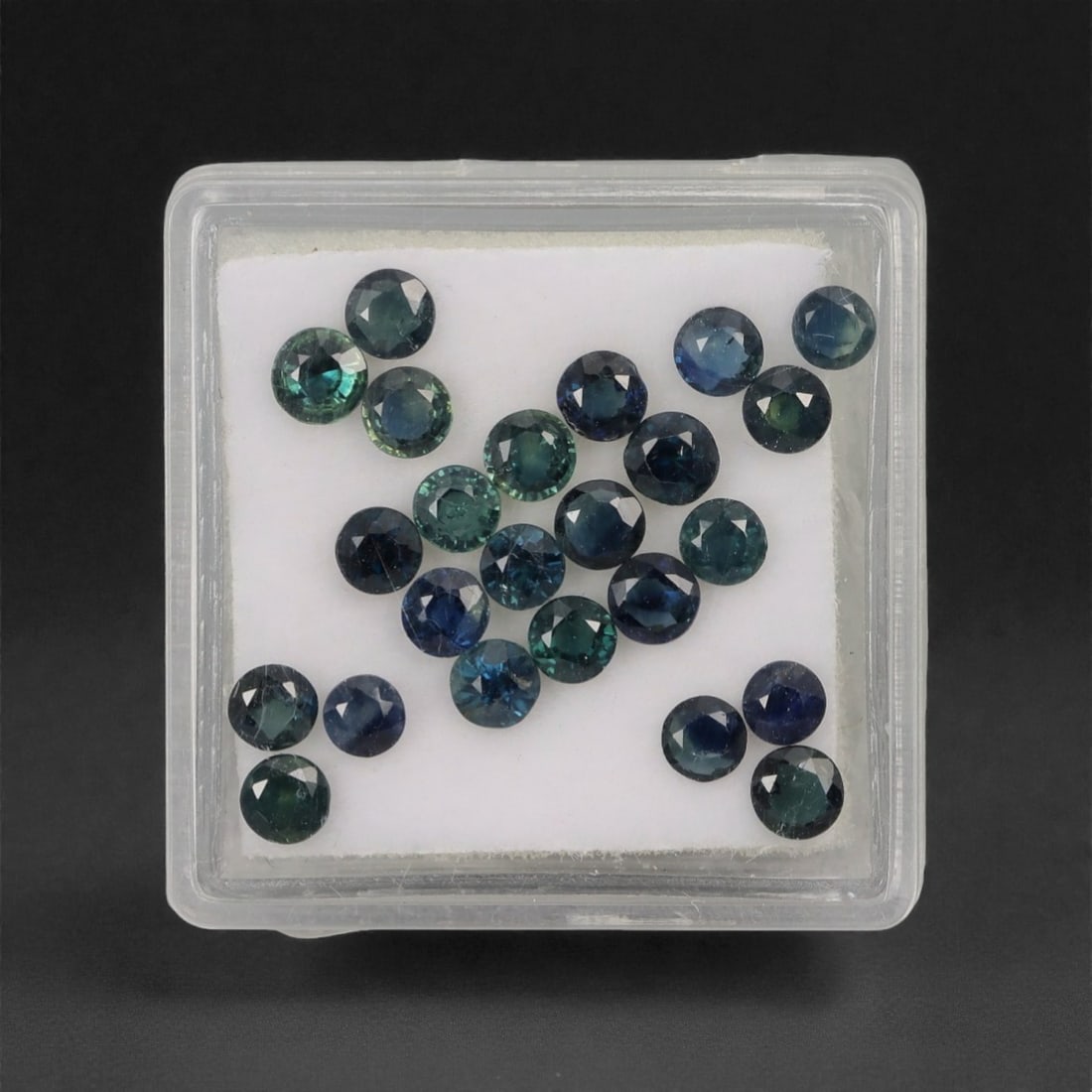 4.28 Carats Multitone Parti Sapphire Parcel - Natural Australian Stones, 27XL: This vibrant parcel of parti sapphires showcases a rich spectrum of deep teal, forest green, and moody blue tones, each round, faceted stone exhibiting dynamic color zoning that shifts and glows under