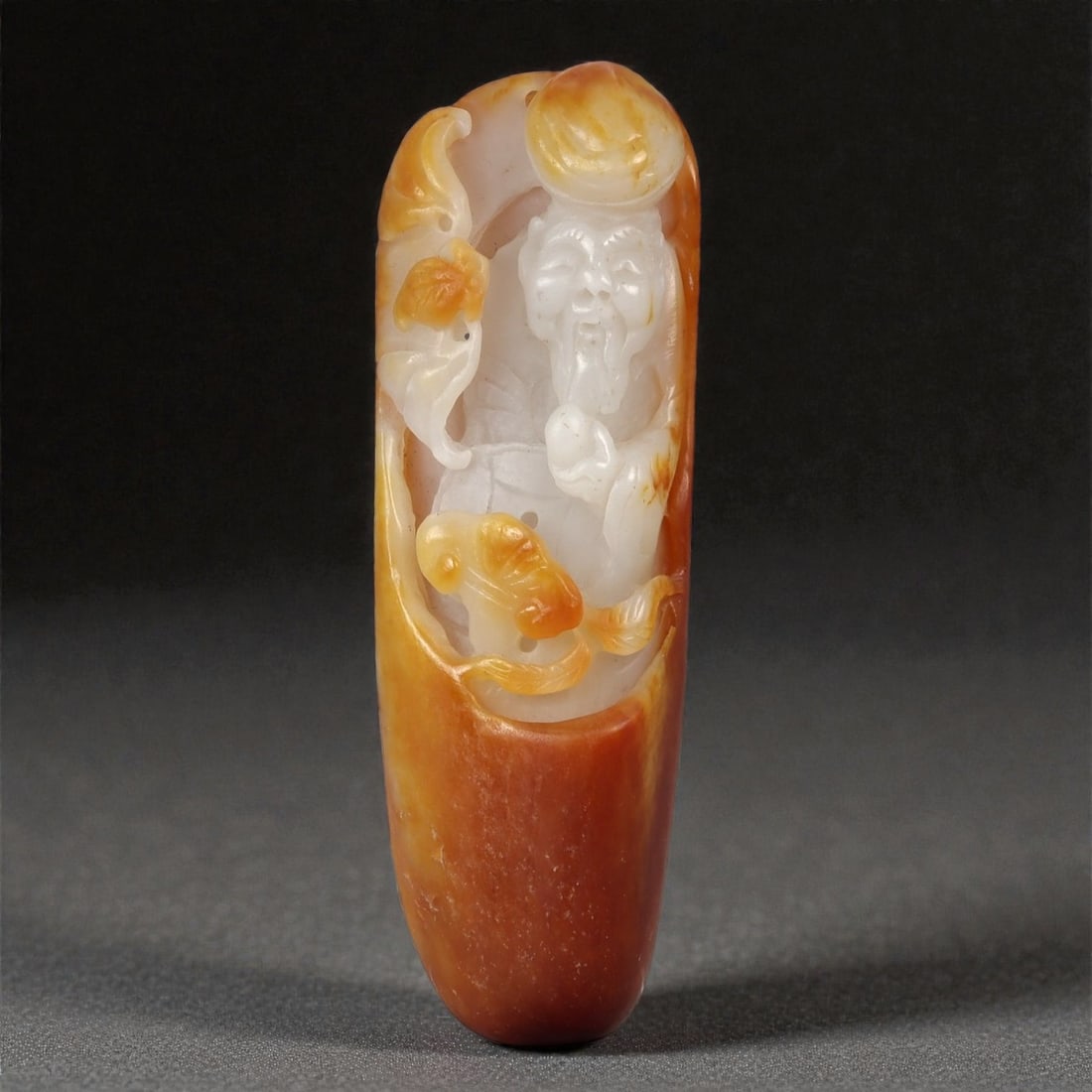 A Chinese Nephrite Jade Figural Pendant, 20th Century, 27FB: Carved from pale celadon to creamy white nephrite jade with extensive russet and amber-colored skin retained from the original stone, the pendant is worked in relief with a figural composition framed