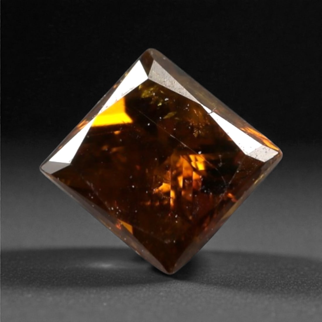 0.25 Carats Orangy Red Fancy Diamond - Princess Cut, 200A: This rare fancy orangy red diamond captivates with a vivid, warm hue that evokes the intensity of a glowing ember and the richness of a sunset. Cut in a well-proportioned princess shape, the stone's f