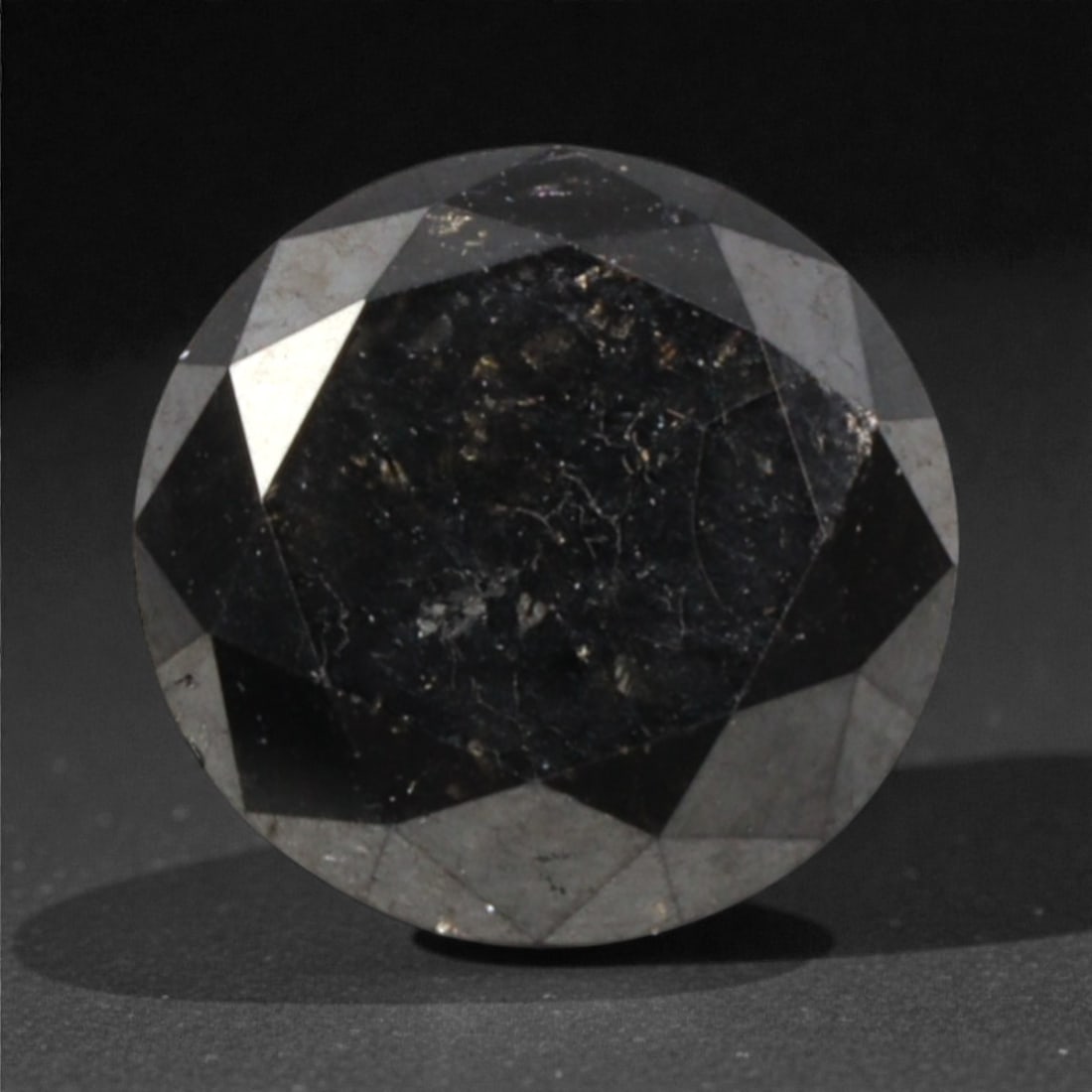 1.22 Carats Black Diamond - Round Brilliant Cut, 289A: This substantial black diamond captivates with a deep, opaque black hue that evokes the intensity of polished obsidian and the mystery of a midnight sky. Cut in a well-proportioned round brilliant sha