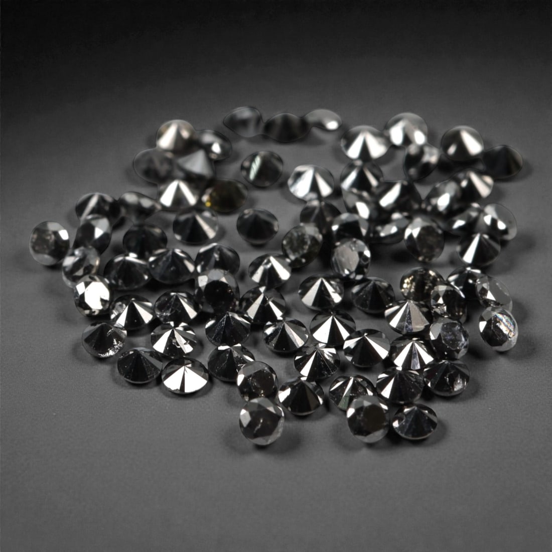 75 Pieces Black Diamond Parcel - Round Brilliant Cut, 1.4mm, 169A: This versatile parcel of 75 loose black diamond gems captivates with a deep, opaque black hue that evokes the intensity of polished obsidian and the mystery of a midnight sky. Each stone is cut in a w