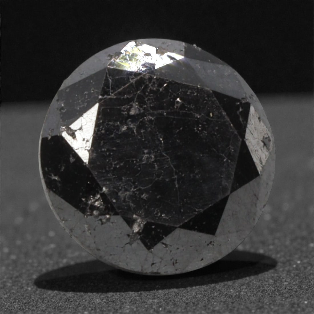 1.98 Carats Black Diamond - Round Brilliant Cut, 287A: This substantial black diamond captivates with a deep, opaque black hue that evokes the intensity of polished obsidian and the mystery of a midnight sky. Cut in a well-proportioned round brilliant sha