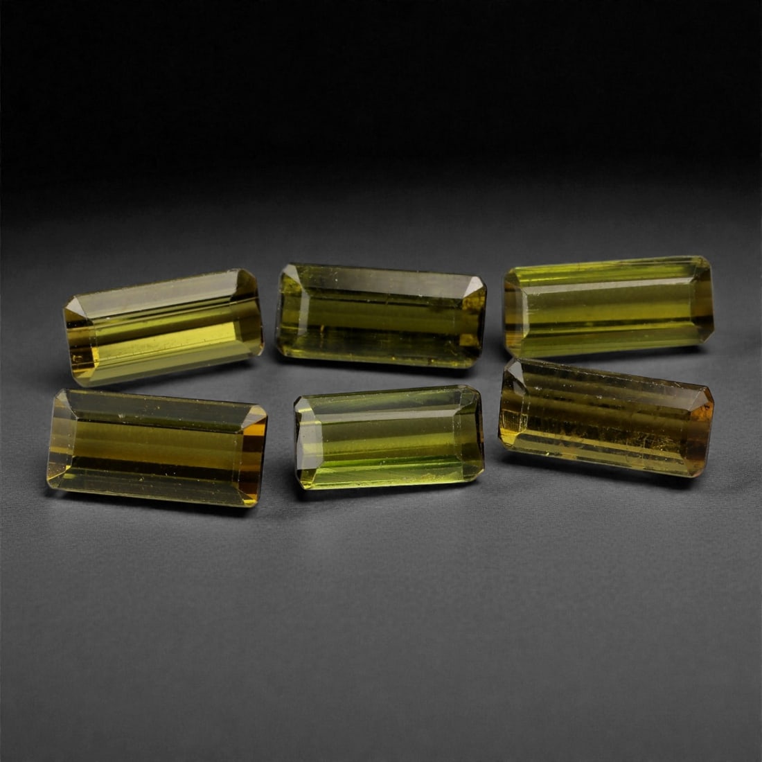 9.01 Carats Golden Olive Tourmaline Parcel - Natural Nigerian Stones, 7-9mm, 4XK: This sleek parcel of long baguette-cut tourmalines offers a refined blend of golden olive and mossy green hues. With clean lines and high transparency, the stones exhibit crisp brilliance along their