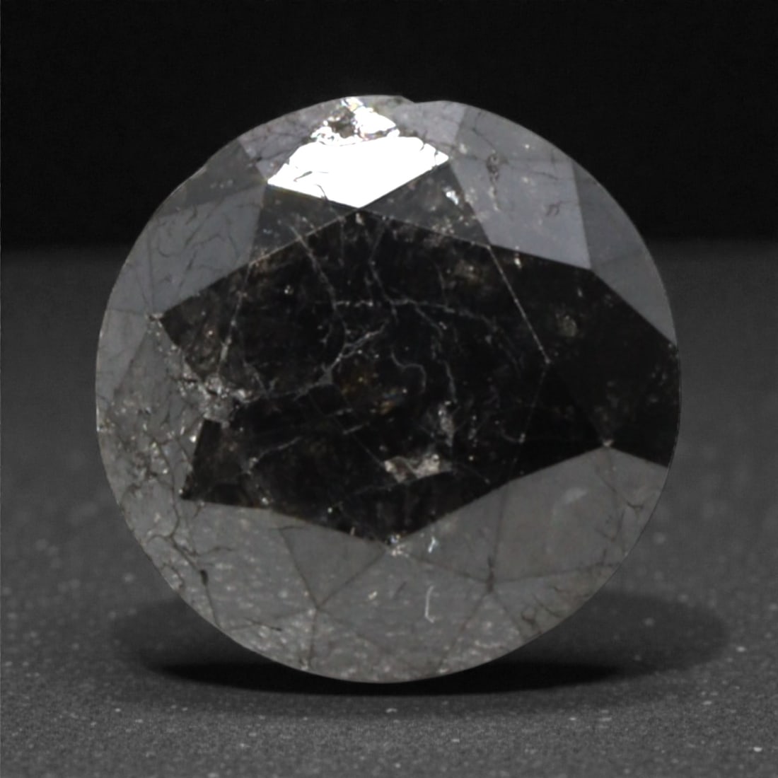 1.30 Carats Black Diamond - Round Brilliant Cut, 290A: This substantial black diamond captivates with a deep, opaque black hue that evokes the intensity of polished obsidian and the mystery of a midnight sky. Cut in a well-proportioned round brilliant sha