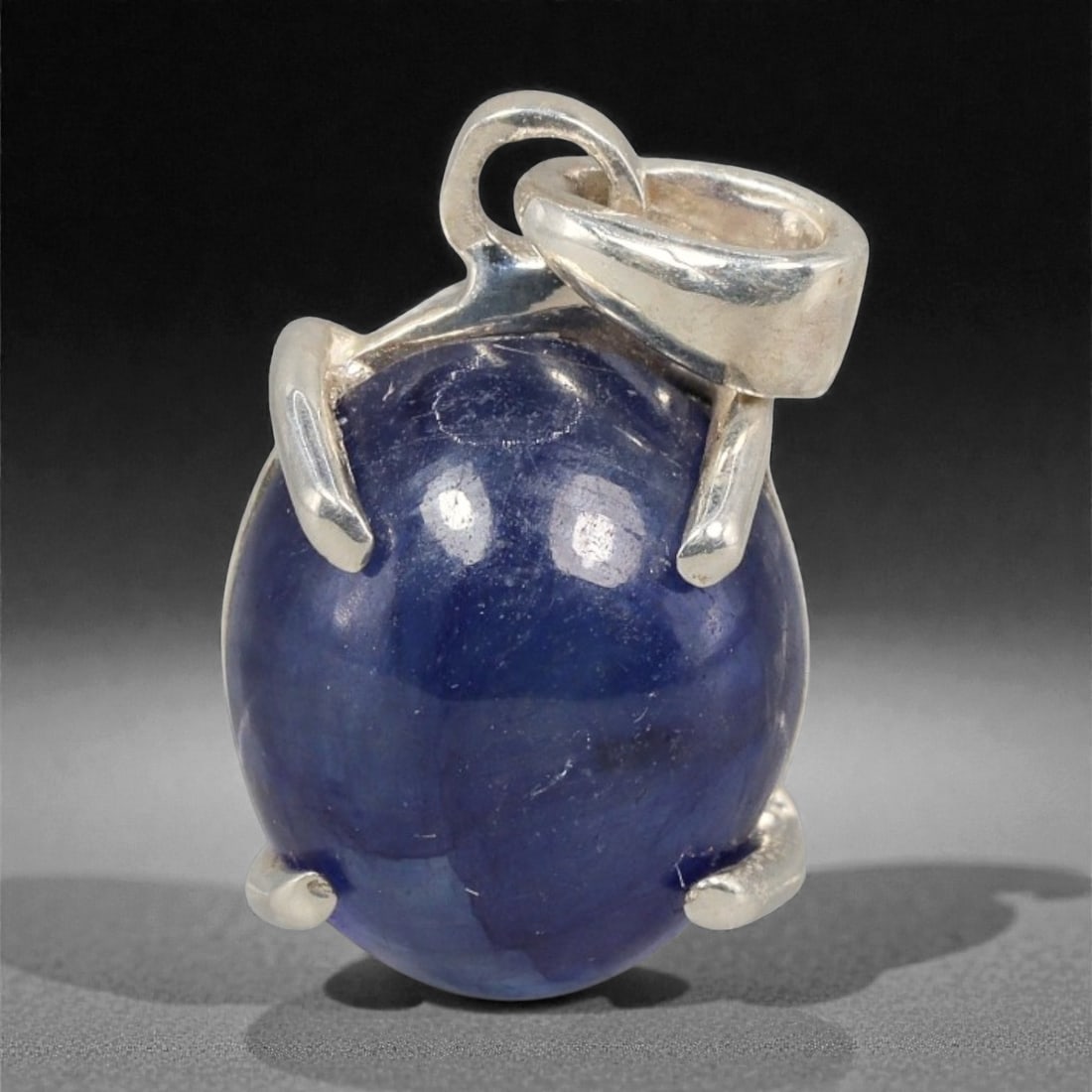 10.86 Carats Deep Blue Sapphire Cabochon Pendant - Sterling Silver Setting, 151A: This striking pendant features a substantial deep blue sapphire cabochon, set in a polished sterling silver frame stamped 925. The cabochon's smooth, domed surface radiates with a rich, velvety blue h