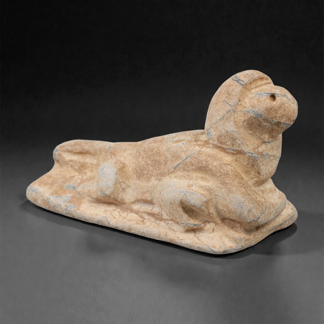 A Near Eastern Stone Zoomorphic Figure, 2nd-1st Millennium BCE, 49FM: Carved from light beige stone with natural surface fissures and tonal variation, the object is formed as a zoomorphic figure, likely representing a quadruped, shown in a recumbent pose on an integrate