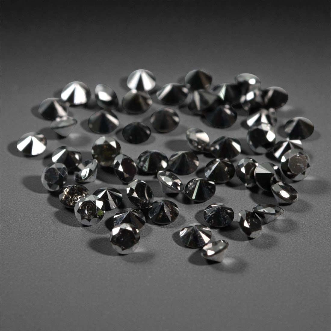 50 Pieces Black Diamond Parcel - Round Brilliant Cut, 1.7mm, 170A: This versatile parcel of 50 loose black diamond gems captivates with a deep, opaque black hue that evokes the intensity of polished obsidian and the mystery of a midnight sky. Each stone is cut in a w