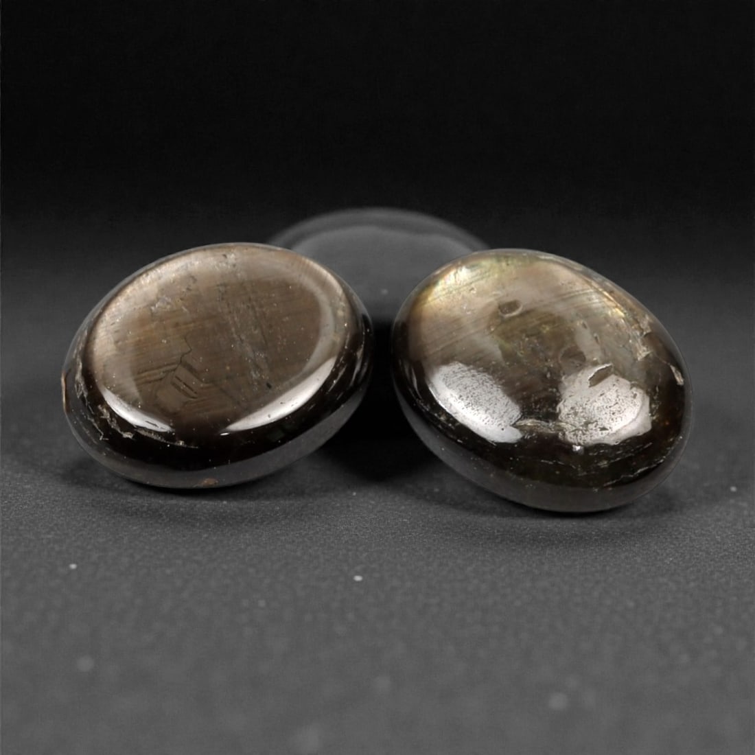 4.24 Carats Dark Brownish Grey Star Sapphire Parcel - Natural Sri Lankan Stones, 386A: This striking parcel of two loose star sapphires captivates with their deep, earthy tones and the subtle, luminous asterism that emerges under direct light. The smooth, cabochon-cut surfaces catch and
