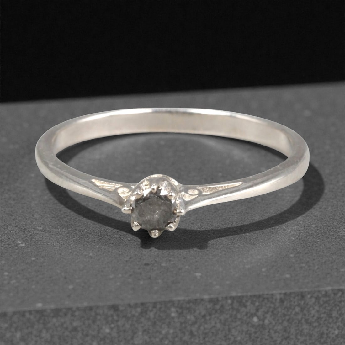 Sterling Silver (925) Ring with Salt-and-Pepper Diamond - Size 6.5 US, 118A: This delicate ring is crafted from polished sterling silver, featuring a slender band with subtle engraved scrollwork at the shoulders. The centerpiece is a round-cut salt-and-pepper diamond, held in