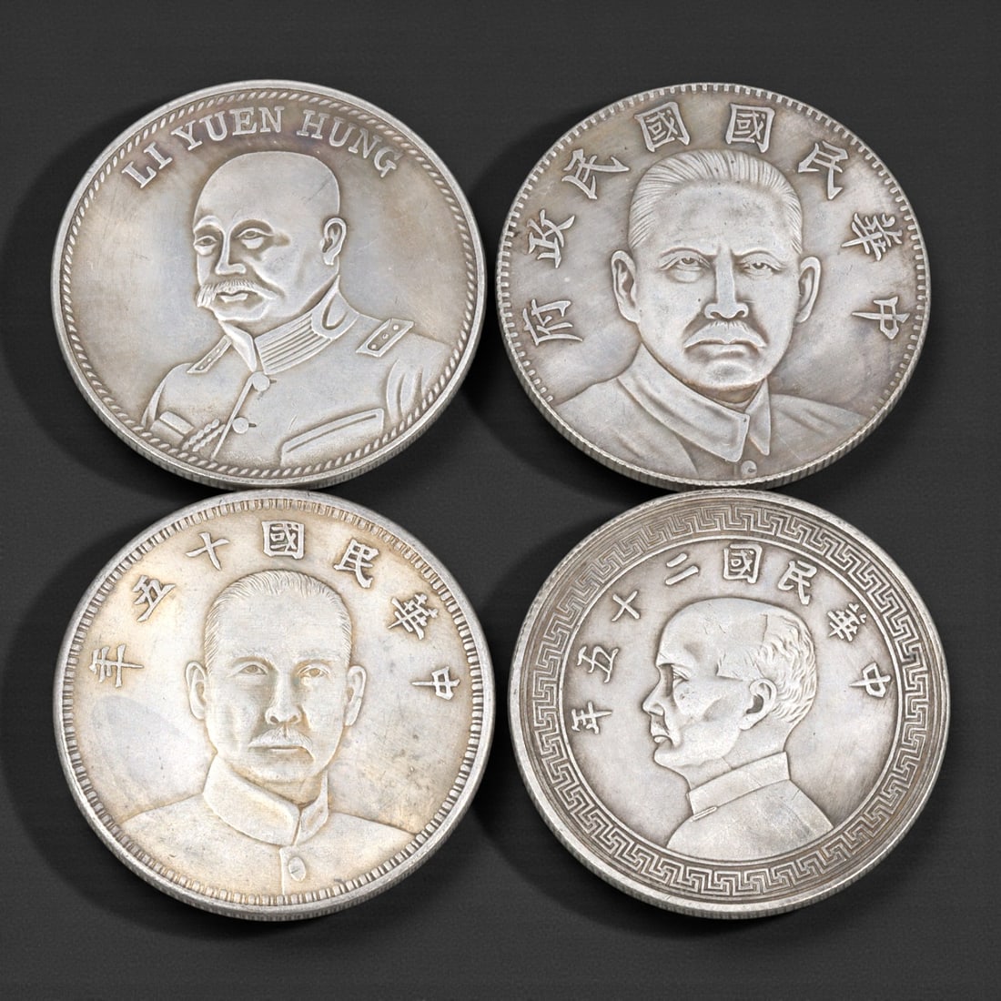 A Group of Four Chinese Commemorative Coins, 20th Century, 48FJ: The group comprises four circular Chinese commemorative coins, each measuring approximately 38 mm in diameter, struck in base metal alloy and produced for commemorative or collector purposes rather th