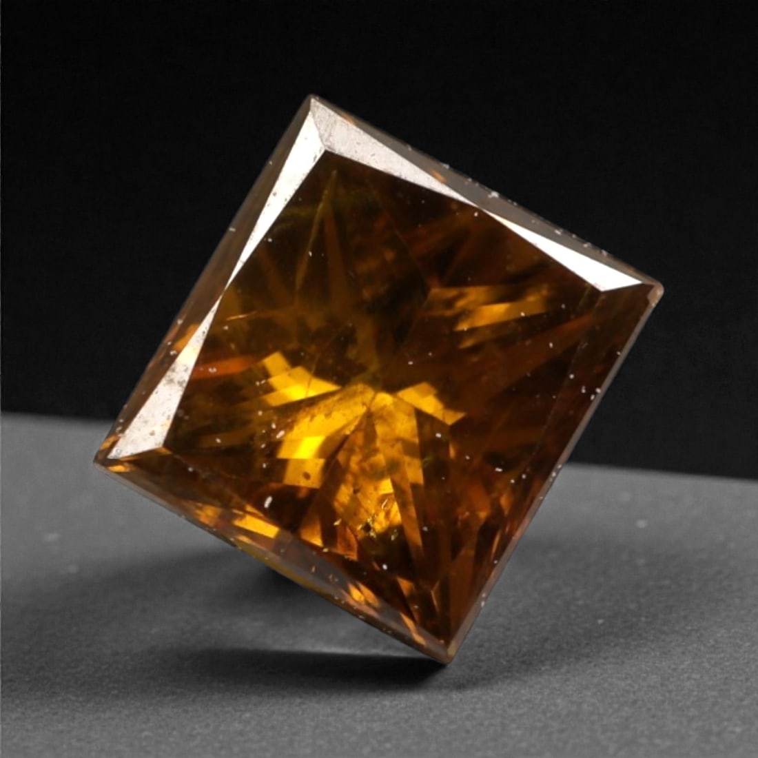 0.39 Carats Orangy Red Fancy Diamond - Princess Cut, 182A: This rare fancy orangy red diamond captivates with a vivid, warm hue that evokes the intensity of a glowing ember and the richness of a sunset. Cut in a well-proportioned princess shape, the stone's f