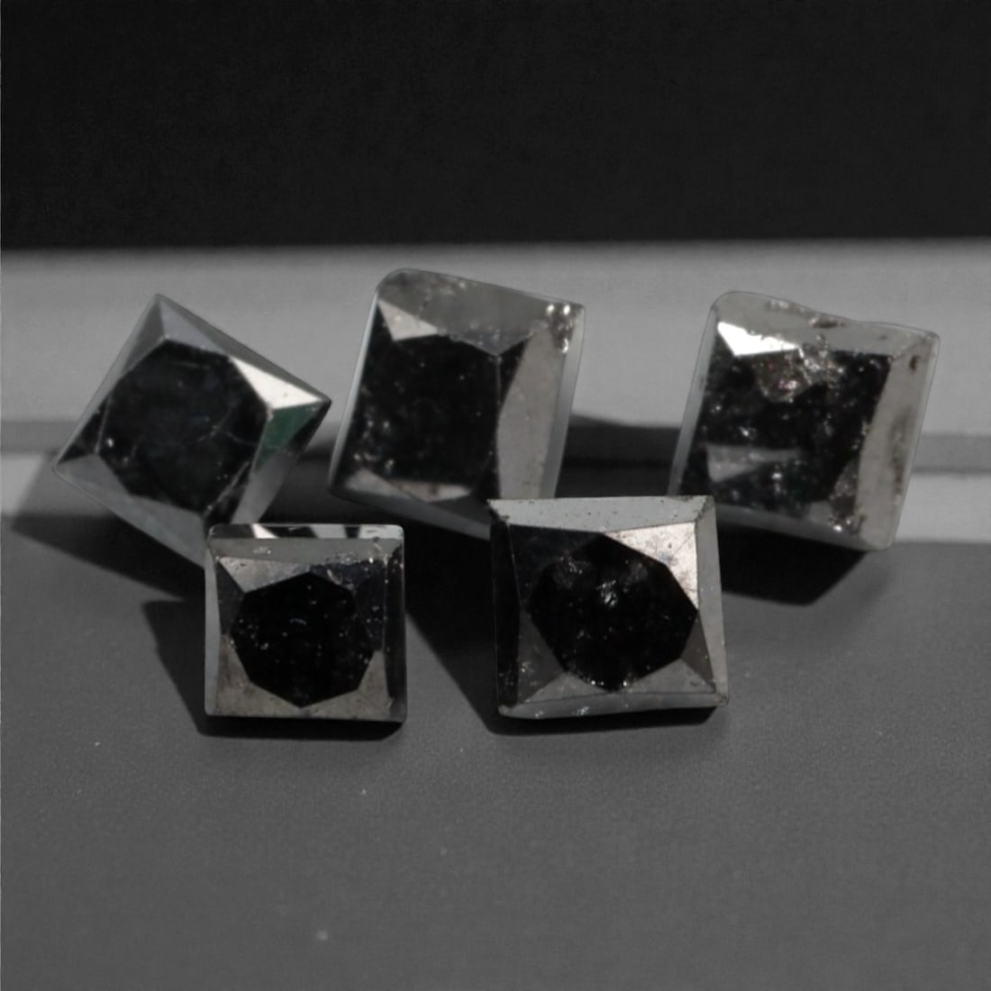 1.03 Carats Black Diamond Parcel - Princess Cut, 228A: This striking parcel of five loose black diamond gems captivates with a deep, opaque black hue that evokes the intensity of polished obsidian and the mystery of a midnight sky. Each stone is cut in a