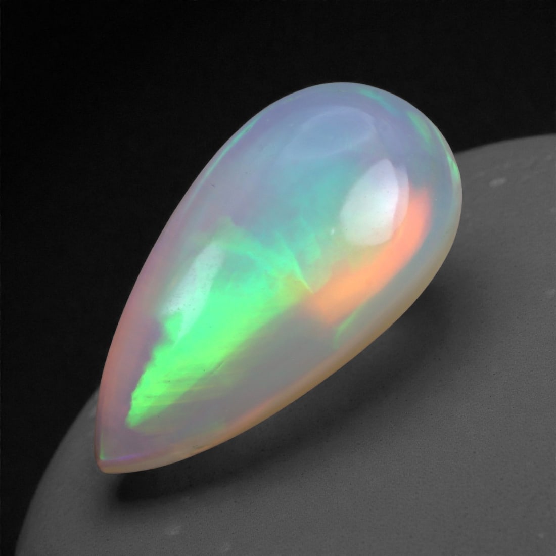 3.00 Carats Play-of-Color Welo Opal - Natural Ethiopian Gem 16x8mm, 57XA: This captivating Welo opal gleams with a luminous cascade of multi neon color that ripple across the stone's surface with every movement. The play-of-color is vivid and well-distributed, presenting a
