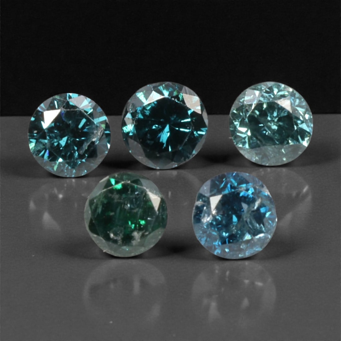 5 Pieces Irradiated Blue Diamond Parcel - Round Brilliant Cut, 2.4mm, 260A: This striking parcel of five loose irradiated blue diamond gems captivates with a vivid, cool blue hue that evokes the intensity of a deep ocean and the clarity of a winter sky. Each stone is cut in a