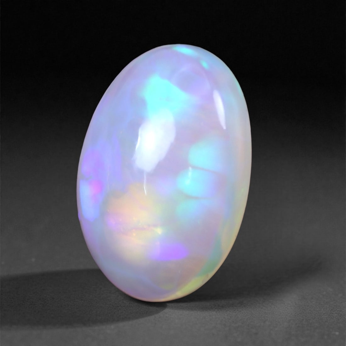 3.06 Carats Celestial Glow Welo Opal - Natural Ethiopian Gemstone 13.2x9.2x5.1mm, 21XH: This ethereal Welo opal glows with dreamy hues of electric blue, violet, and soft lilac, drifting through a delicate translucent body. The gem's pastel fire evokes the northern lights-fluid, serene, a