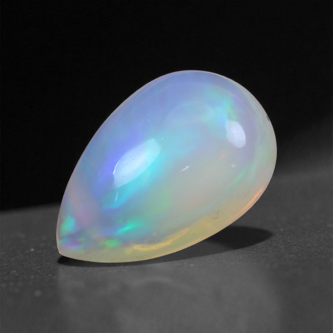 7.10 Carats Aurora Mist Welo Opal - Natural Ethiopian Gemstone 16.6x11x8.1mm, 53XH: This exceptional Welo opal glows with radiant hues of icy blue, mint green, and warm peach, all shimmering beneath a translucent, cloud-like body. The colors appear to drift like mist through the ston