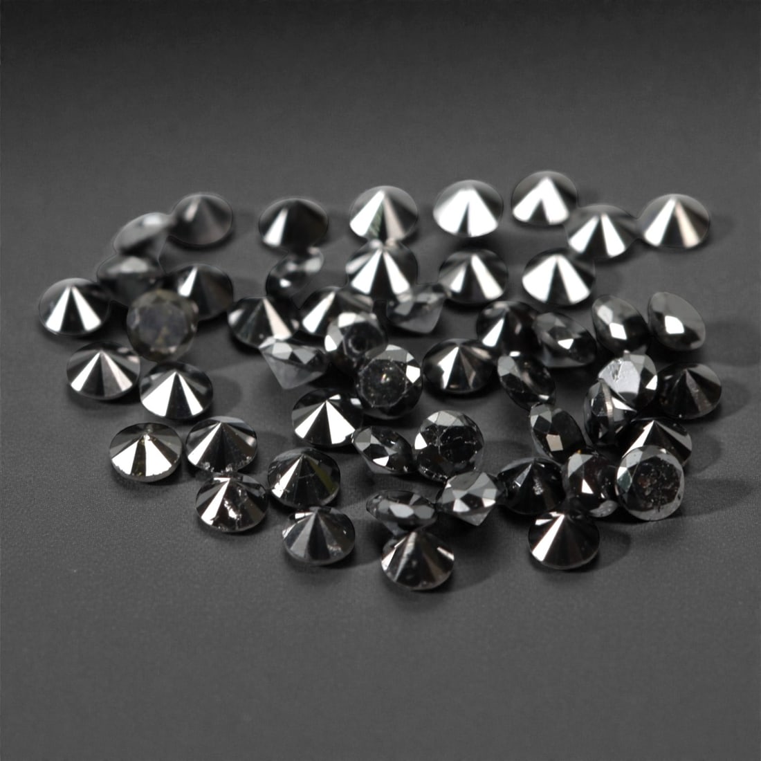 50 Pieces Black Diamond Parcel - Round Brilliant Cut, 1.7mm, 168A: This versatile parcel of 50 loose black diamond gems captivates with a deep, opaque black hue that evokes the intensity of polished obsidian and the mystery of a midnight sky. Each stone is cut in a w