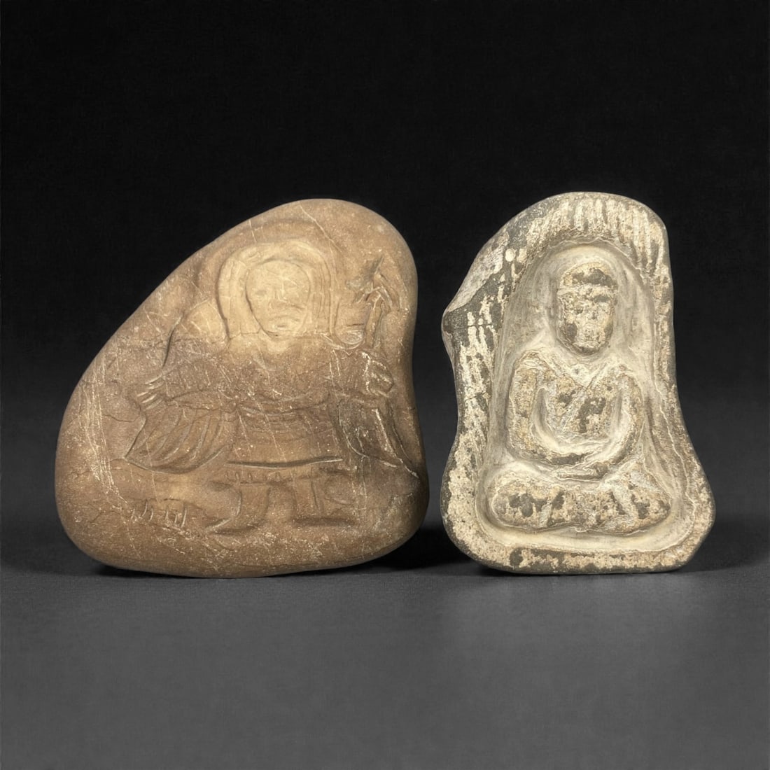 A Group of Two Christian Period Stone Carvings, 4th-7th Century, 2FN: Carved from stone with natural tonal variation, surface wear, and mineral encrustation, the two objects depict religious figures in shallow relief, set within irregular stone matrices. The leftmost ca