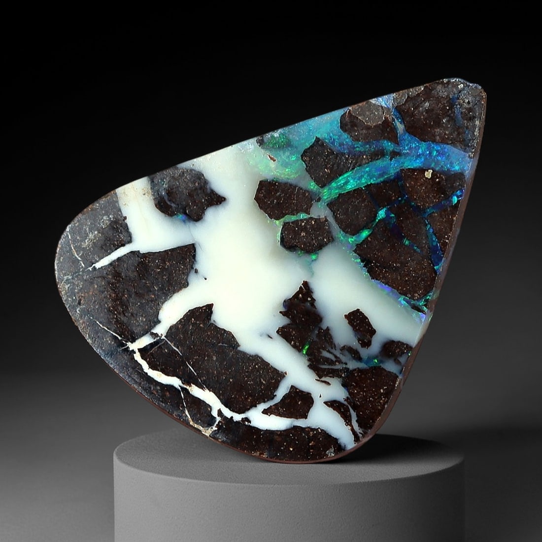 3.09ct Boulder Opal Cabochon - Dynamic Matrix & Play-of-Color Specimen, 55XM: This 3.09ct boulder opal cabochon, measuring 11x8mm, is a striking example of Australia's iconic gemstone, showcasing the raw beauty of nature's artistry. The triangular cabochon is polished to a smoo