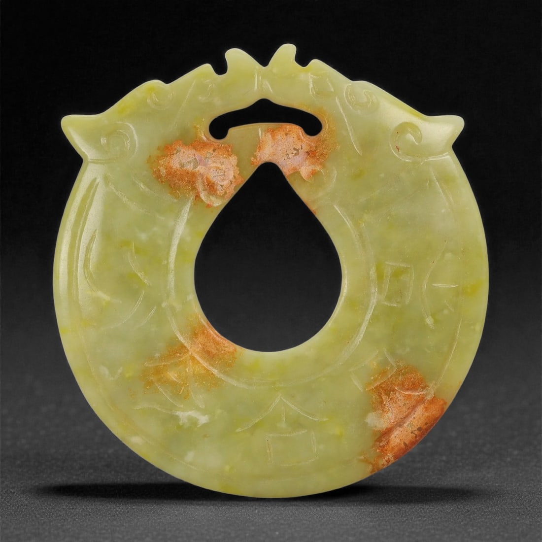 A Chinese Hetian Nephrite Jade Bi Disc, 20th Century, 56FD: Carved from pale yellow-green Hetian nephrite jade with areas of natural russet skin adhering to the surface. The disc is worked with a circular outer profile and a central perforation, with a shallow