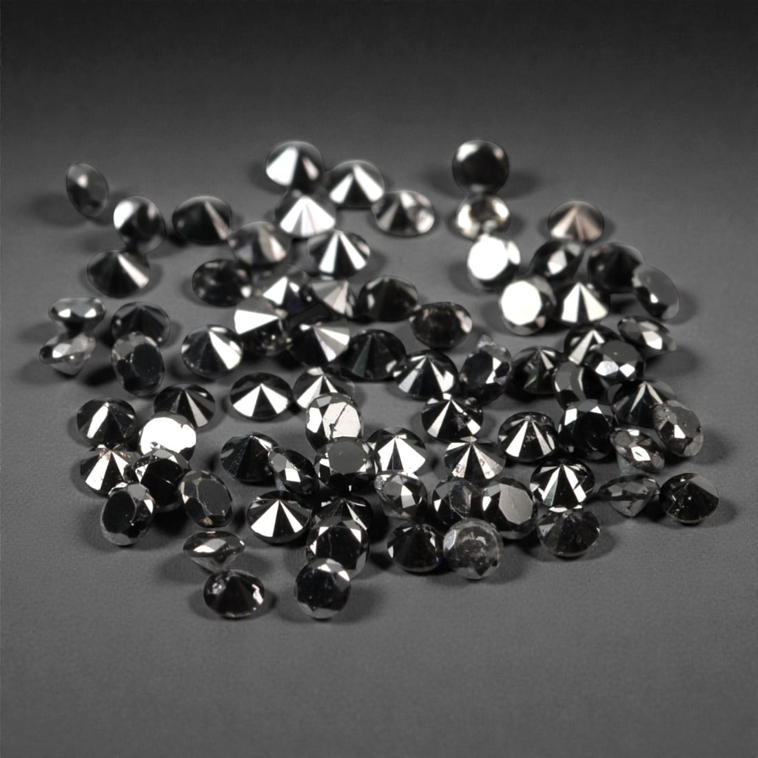 75 Pieces Black Diamond Parcel - Round Brilliant Cut, 1.4mm, 163A: This versatile parcel of 75 loose black diamond gems captivates with a deep, opaque black hue that evokes the intensity of polished obsidian and the mystery of a midnight sky. Each stone is cut in a w