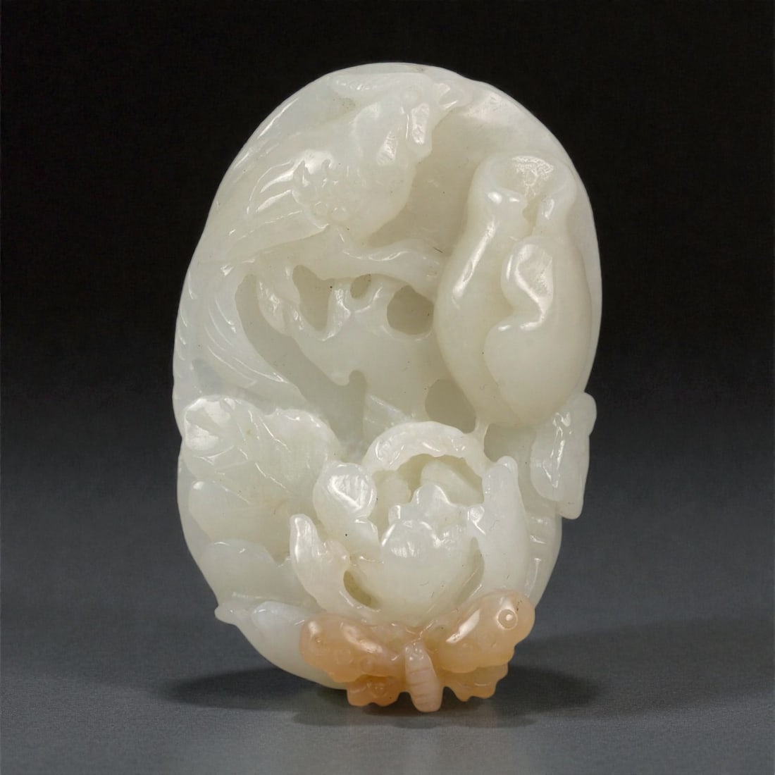 A Chinese Nephrite Jade Figural Pendant, 20th Century, 48FB: Carved from pale white nephrite jade with soft translucency and minor natural inclusions, the pendant is worked in relief with a compact figural composition. The design depicts a grouping of animals,