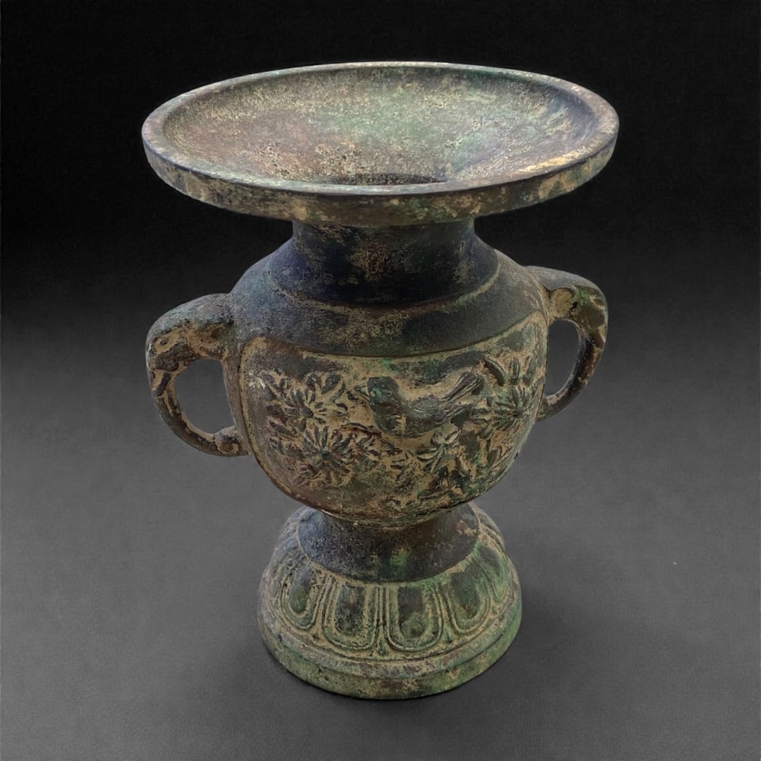 An Antique Chinese Bronze Vase, 19th Century, 880g, 55AA: Cast from bronze with a textured green and brown patina, the vase features a wide, flared rim, a short cylindrical neck, and a bulbous body tapering to a stepped, decorated foot. Two openwork loop han