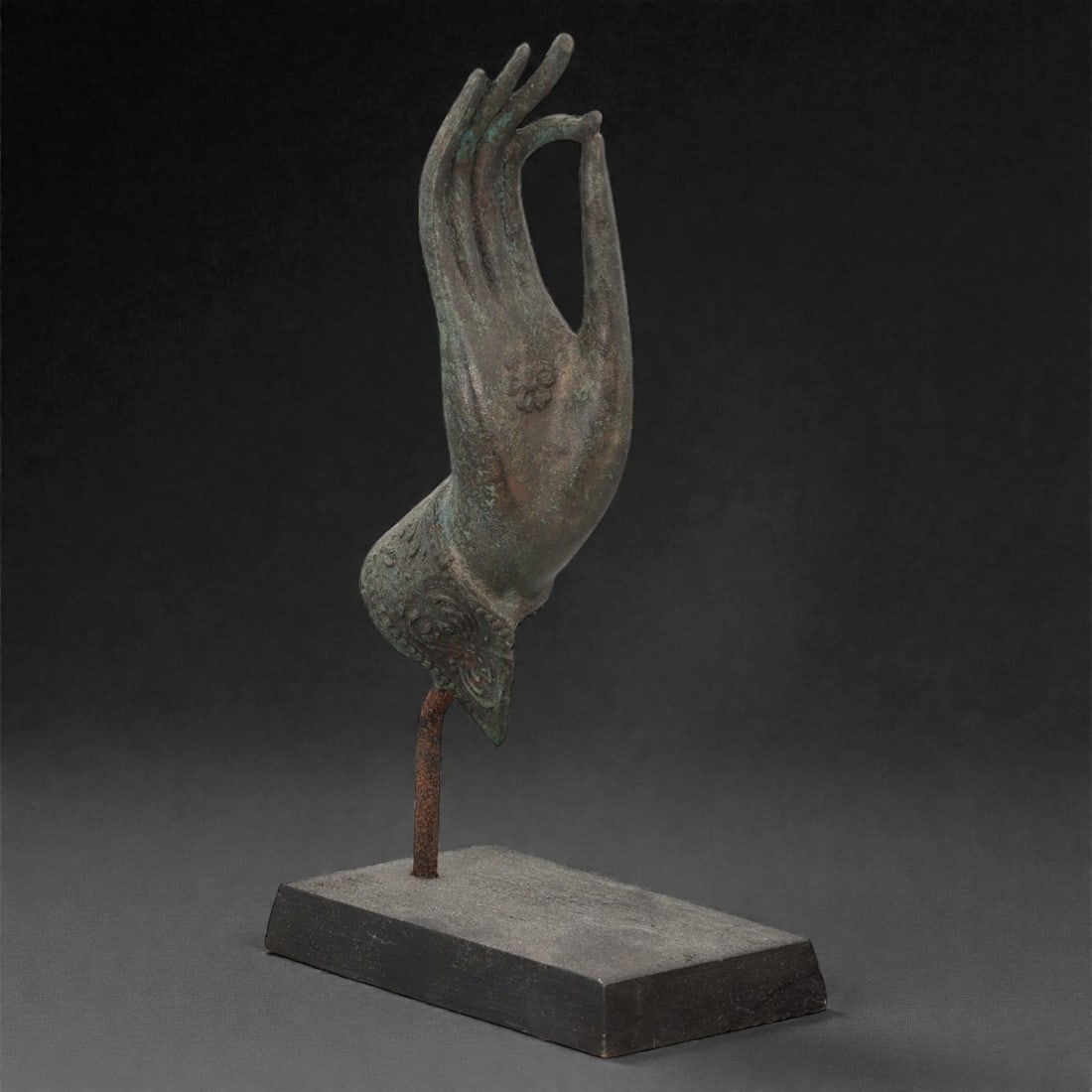 A Southeast Asian Bronze Buddha Hand, 20th Century, 34FN: Cast from dark patinated bronze with subtle greenish-verdigrise encrustation across the surface, the hand depicts the vitarka mudra, with the thumb and index finger forming a circular loop and the rem