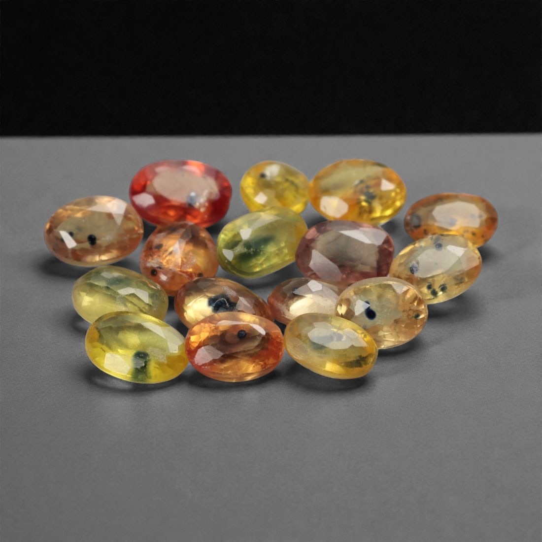 6.51 Carats Multicolor Songea Sapphire Parcel - Natural Tanzanian Oval Stones, 28ZH: This vibrant parcel of Songea sapphires presents a stunning chromatic gradient, ranging from vivid golden yellow and honey orange to rich terracotta red and soft lime green. Each oval-cut gem, calibra